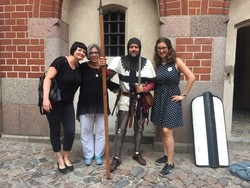 Drei Mitarbeiterinnen aus der Stadt Monheim am Rhein mit einem Mann im mittelalterlichen Ritter-Kostüm