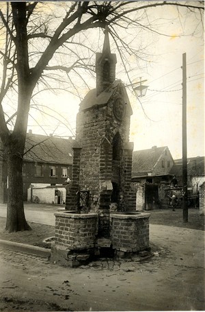 Ein altes schwarz-weiß Foto: ein schmaler Turm aus Stein, an drei Seiten sind kleine gemauerte Becken