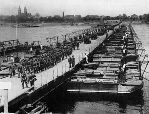 altes schwarz-weiß Foto: eine mobile Brücke über den Rhein, auf der Brücke maschiert eine große Gruppe Soldaten