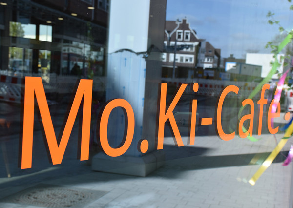 Noch spiegelt sich in den Scheiben des Mo.Ki-Cafés die Baustelle auf der Heinestraße.