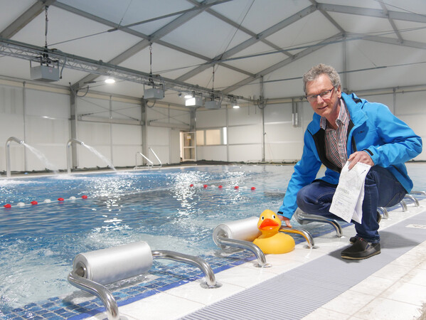 André Zierul prüft die Wassertemperatur im neuen Becken. Ein doppelwandiges beheiztes Zelt verhindert Wärmeverlust. Fotos: Pia Mahr