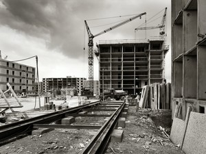 Bild in schwarz-weiß: Die Baustelle im Berliner Viertel, halb fertige Gebäude, dazwischen Baukräne und Schienen