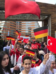 Die Kinder und Jugendlichen der Tanzgruppe wedeln mit Fähnchen der deutschen und türkischen Flagge