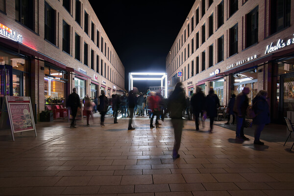 Der Kubus bildet vor allem in den Abendstunden den Mittelpunkt des neuen Monheim-Mitte-Boulevards. Foto: Michael Hotopp