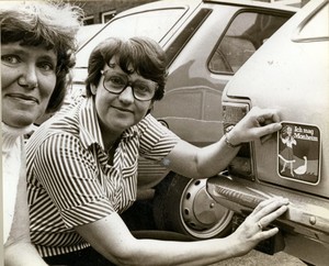Ingeborg Friebe klebt einen Aufkleber mit den Worten "Ich mag Monheim" an den Kofferraum eines Autos