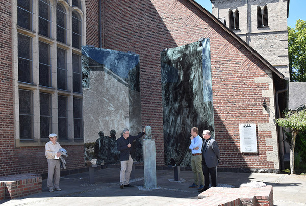 Die aus Bruchziegeln gemauerte Sitzgelegenheit zeichnet den Grundriss des 1945 zerstörten alten Chors nach. Geschaffen wurde ein kraftvoller Ort, der zum Nachdenken und Verweilen einlädt.    