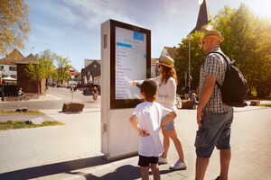 A family standing in front of a display screen