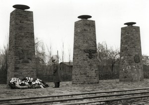 Ein Teil der Freilichtbühne: drei hohe Steinblöcke mit großen Schalen, vor dem linken Steinblock liegt Blumenschmuck