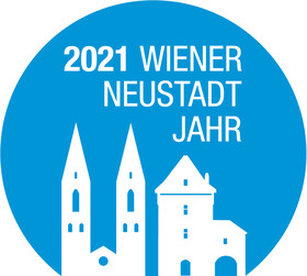 Das Logo des Wiener Neustadt Jahr 2021: In weiß auf einem blauen Kreis sind Sehenswürdigkeiten aus Wiener Neustadt abgebildet