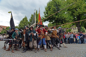 Viele Menschen in mittelalterlichen Kostümen und mit mittelalterlichen Waffen, im Hintergrund Zuschauer
