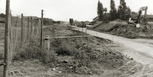 Die heutige Baumberger-Chaussee im Jahr 1979: eine schmale Straße, rechts und links von der Straße türmt sich Erde auf