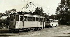Ein schwarz-weiß Foto: eine Straßenbahn, dahinter ein Bus