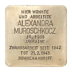 Stolperstein mit der Inschrift: Hier wohnte und arbeitete Alexandra Muroschokocz, JG. 1905, Ukraine, Zwangsarbeit seit 1942, Tot 21.2.1945, Bombenangriff