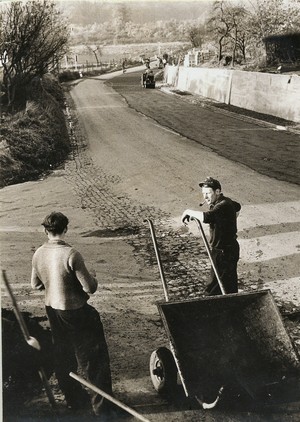 altes schwarz-weiß Foto: zwei Bauarbeiter an der einspurigen Opladener Straße Ortsausgang Baumberg