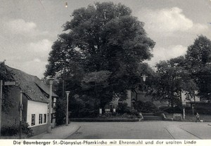 Alte Postkarte mit Blick auf die St.-Dionysius-Pfarrkirche, rechts am Bildrand ist ein kleines, gedrungenes Haus, die alte Schule in Baumberg