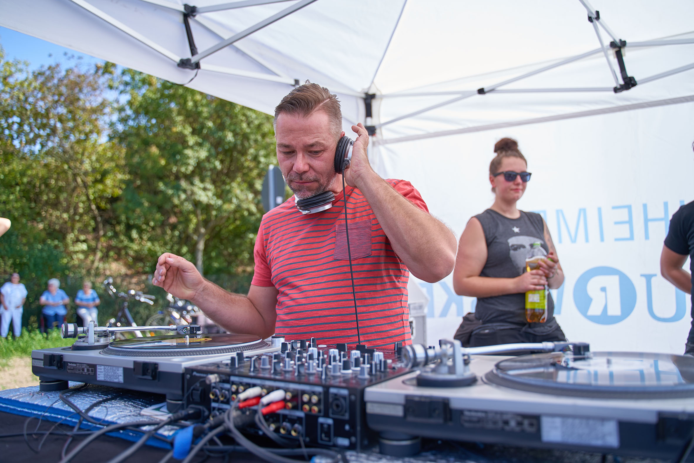 Ein DJ an Plattentellern unter einem Pavillion