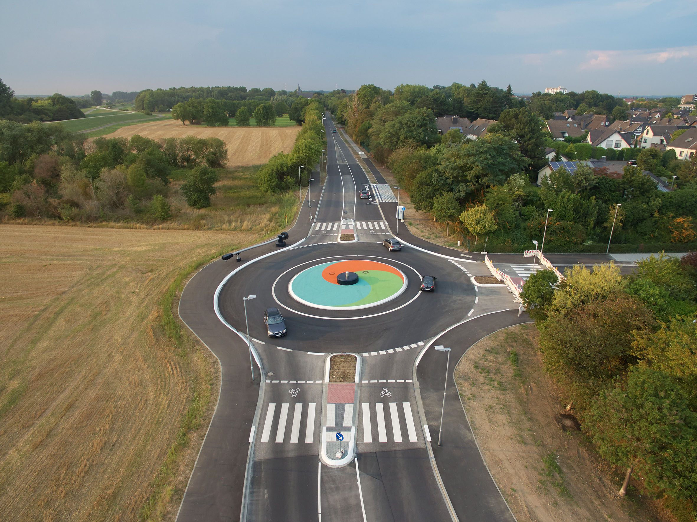 Blick auf den Kreisverkehr mit Kunstwerk beim fließenden Verkehr