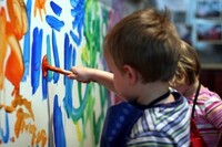 Mehrere Kinder malen an eine weiße Wand